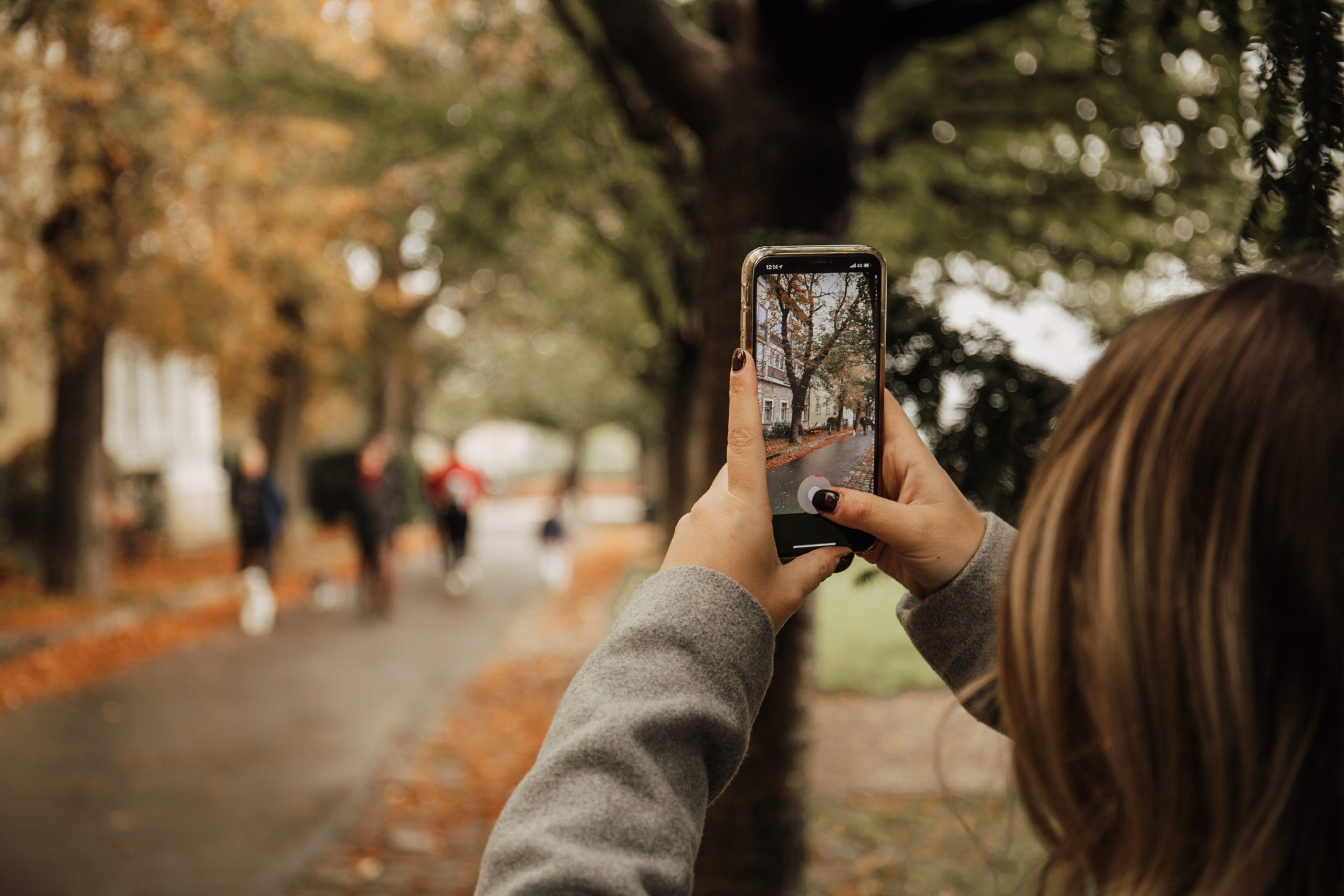 young woman taking photo with an iphone young woman taking photo with an iphone
